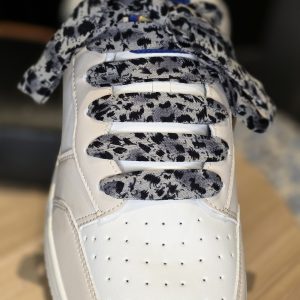 Grey leopard print handmade shoelaces styled on casual sneakers.